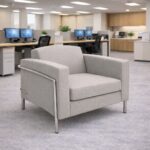 Venus single seater office lounge chair in light grey fabric placed in a contemporary office environment.