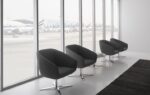 BREK black lounge chairs with metal four-star bases in an airport waiting area
